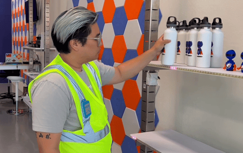 Warehouse worker picks product while wearing a SICK UWB tag-1